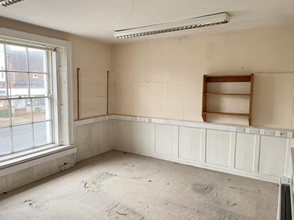 Lot: 40 - LANDMARK FREEHOLD BUILDING WITH PLANNING FOR REDEVELOPMENT - First floor room with painted walls with wood panelling and beige carpet